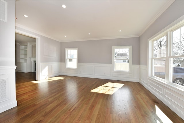 unfurnished room with visible vents, ornamental molding, wood finished floors, a fireplace, and recessed lighting