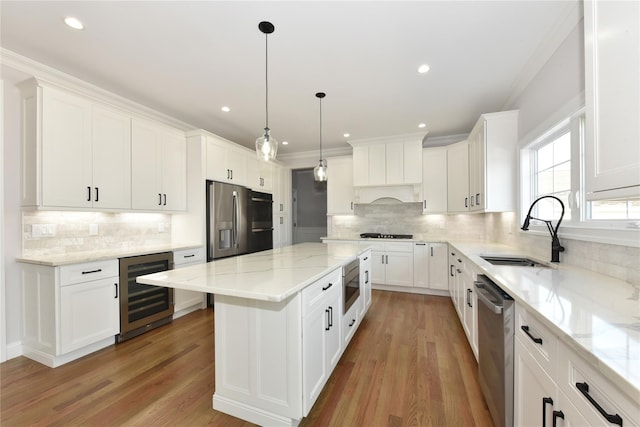 kitchen featuring wine cooler, a center island, stainless steel appliances, white cabinets, and a sink