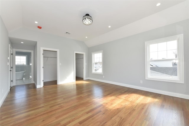 unfurnished bedroom with recessed lighting, vaulted ceiling, baseboards, and wood finished floors