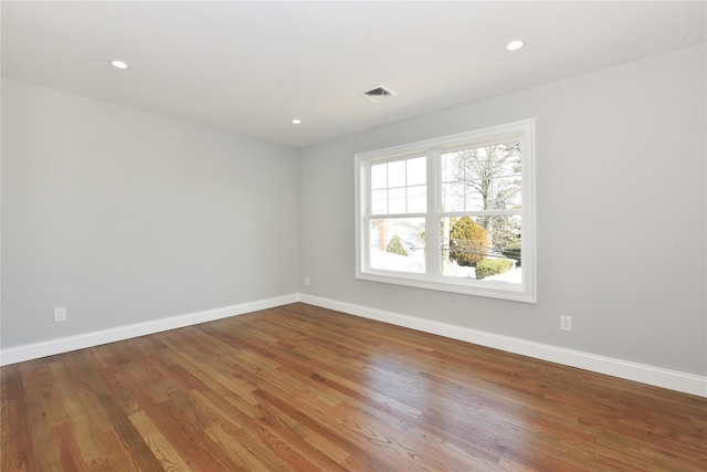 unfurnished room with recessed lighting, visible vents, baseboards, and wood finished floors