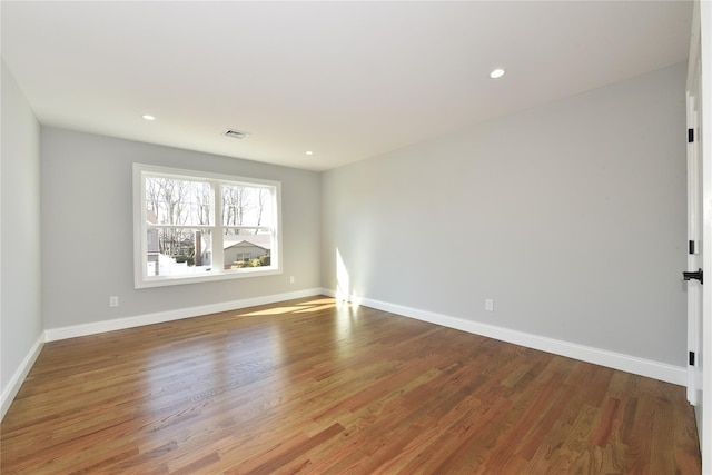 unfurnished room with recessed lighting, visible vents, baseboards, and wood finished floors