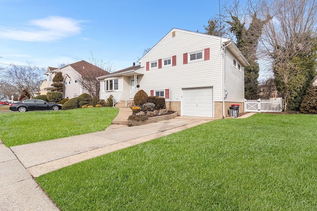 split level home with an attached garage, driveway, a front yard, and fence