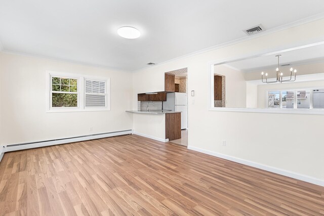 unfurnished living room featuring a baseboard heating unit, visible vents, baseboards, light wood-style floors, and an inviting chandelier