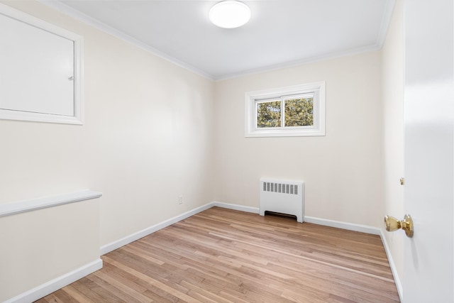 unfurnished room featuring baseboards, ornamental molding, light wood-type flooring, and radiator