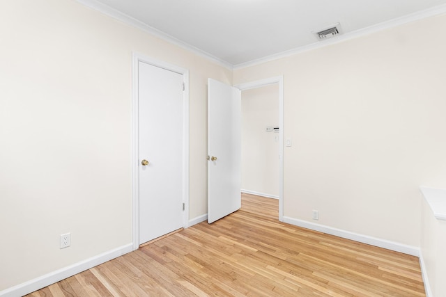 unfurnished room featuring crown molding, baseboards, visible vents, and light wood-style floors