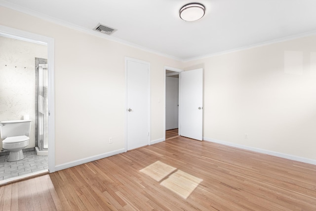 unfurnished bedroom featuring light wood finished floors, baseboards, visible vents, and crown molding