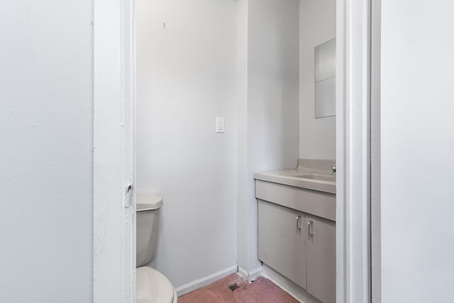 bathroom with vanity, toilet, and baseboards