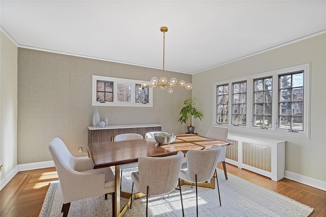 dining space with baseboards, wood finished floors, and ornamental molding