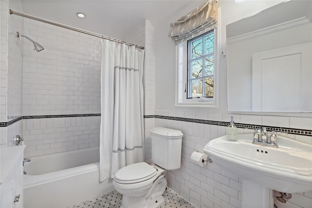 bathroom with tile patterned flooring, toilet, a sink, tile walls, and shower / bath combination with curtain