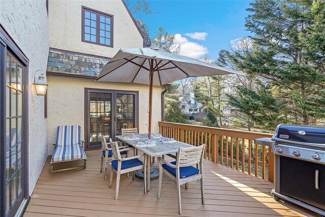 deck with a grill and outdoor dining space