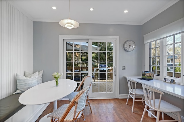 dining room with ornamental molding, recessed lighting, a healthy amount of sunlight, and wood finished floors