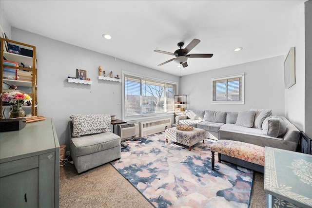 living room featuring radiator heating unit, ceiling fan, carpet floors, a wall mounted AC, and recessed lighting