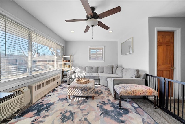 carpeted living room featuring radiator heating unit, a ceiling fan, a wealth of natural light, and recessed lighting