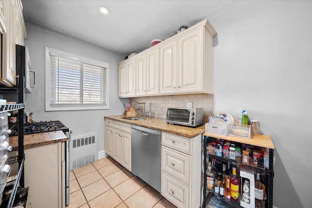 kitchen featuring a toaster, visible vents, decorative backsplash, appliances with stainless steel finishes, and a sink