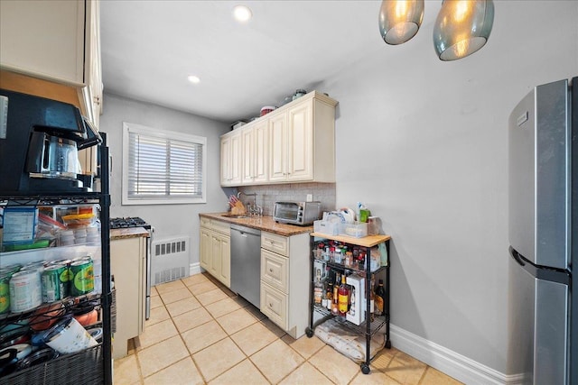 kitchen with tasteful backsplash, visible vents, appliances with stainless steel finishes, light tile patterned flooring, and a sink