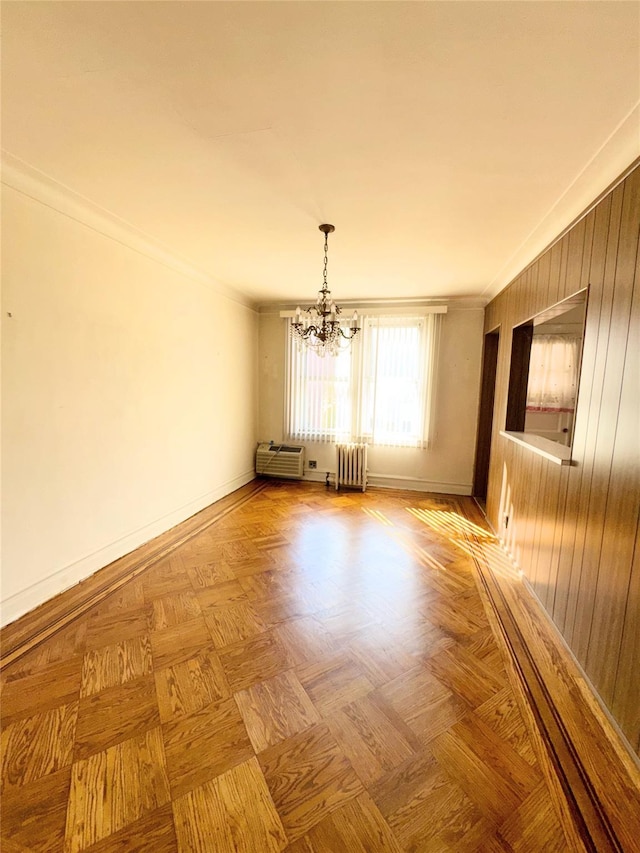 empty room featuring crown molding, radiator heating unit, and baseboards