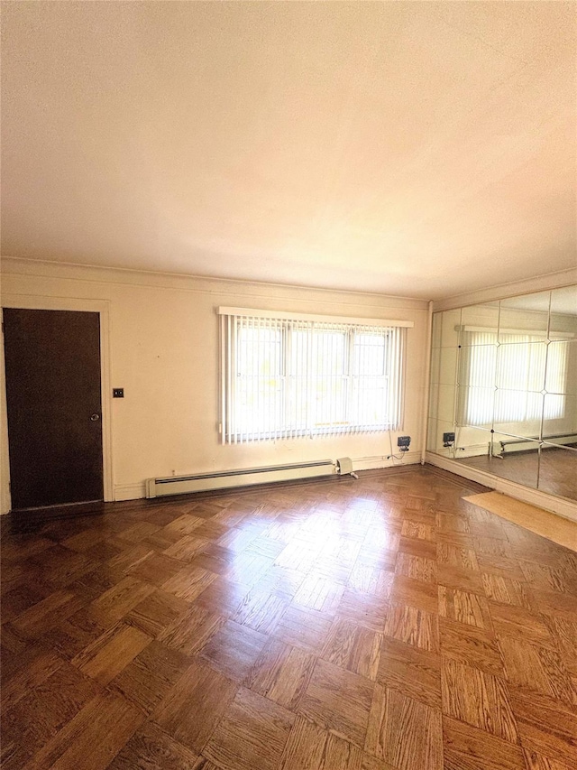 empty room with baseboard heating and ornamental molding