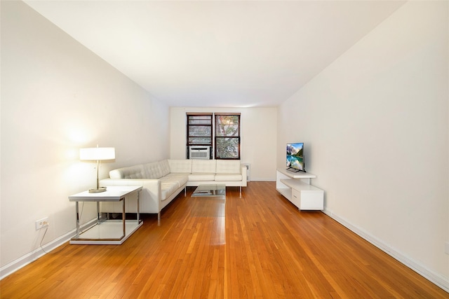 unfurnished living room featuring light wood-style flooring, baseboards, and cooling unit