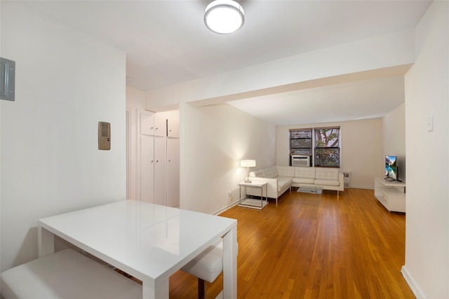 interior space featuring radiator heating unit, baseboards, and wood finished floors