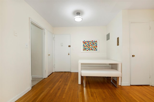 hallway with baseboards and hardwood / wood-style floors