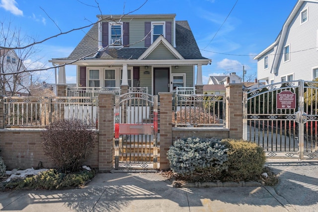 view of front of home featuring a fenced front yard, a gate, and roof with shingles