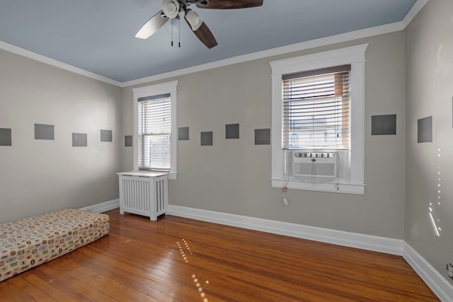 interior space with cooling unit, baseboards, hardwood / wood-style floors, and ornamental molding