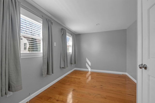 spare room with wood finished floors and baseboards