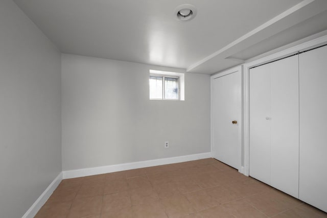 unfurnished bedroom with a closet, baseboards, and light tile patterned floors