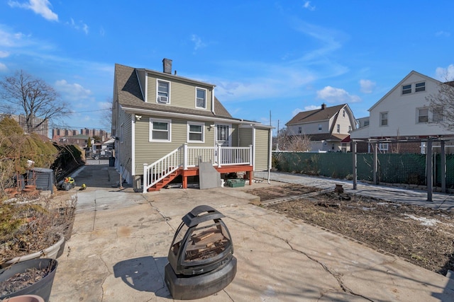 rear view of house with an outdoor fire pit, fence, a residential view, and central AC unit