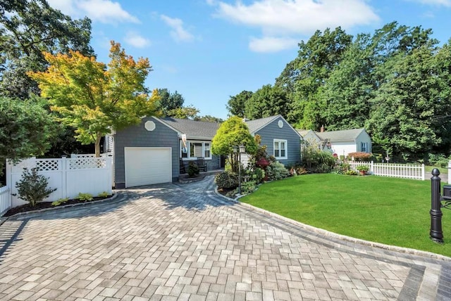 single story home featuring an attached garage, fence, decorative driveway, and a front yard