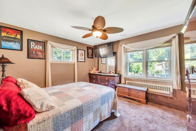 bedroom with radiator, carpet, visible vents, and a ceiling fan