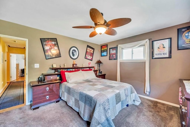 carpeted bedroom with ceiling fan and baseboards