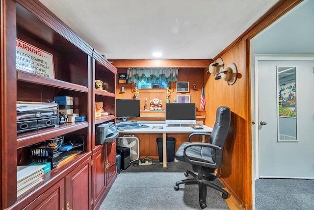 carpeted office space with wood walls