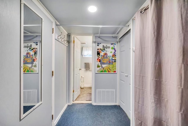 corridor with carpet, visible vents, and baseboards