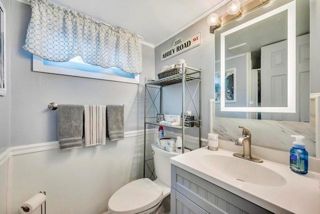 bathroom featuring toilet, crown molding, and vanity