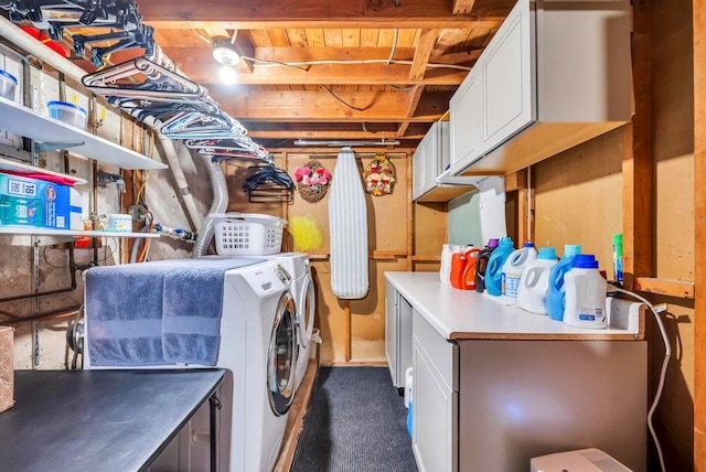 clothes washing area featuring dark colored carpet, cabinet space, and washer and clothes dryer