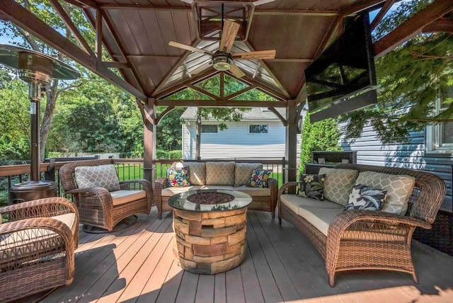 deck with an outdoor living space with a fire pit, ceiling fan, and a gazebo