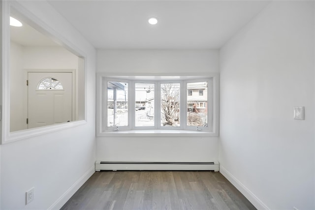 interior space featuring a baseboard radiator, baseboards, wood finished floors, and recessed lighting