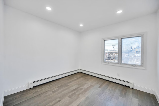 empty room featuring baseboards, wood finished floors, and recessed lighting