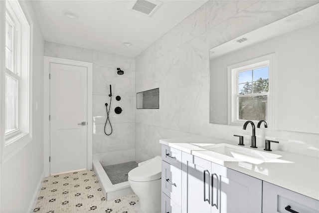 bathroom with a stall shower, visible vents, vanity, and toilet