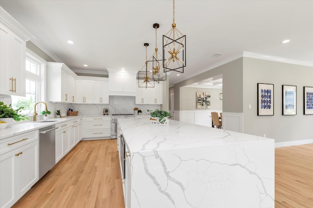 18 Anita Ave, Syosset, NY 11791 - kitchen featuring stainless steel appliances, a center island, a chandelier, light wood-type flooring, and ornamental molding