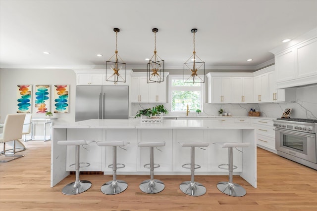 18 Anita Ave, Syosset, NY 11791 - kitchen featuring high end appliances, backsplash, white cabinetry, light wood finished floors, and a center island