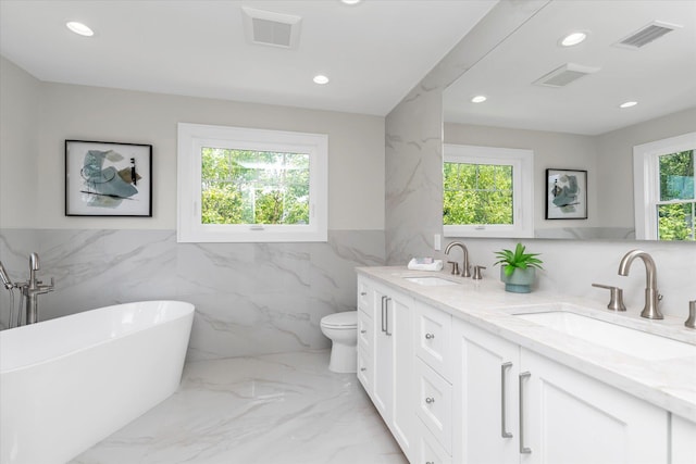 18 Anita Ave, Syosset, NY 11791 - bathroom featuring tile walls, recessed lighting, double vanity, a soaking tub, and marble tiled floors