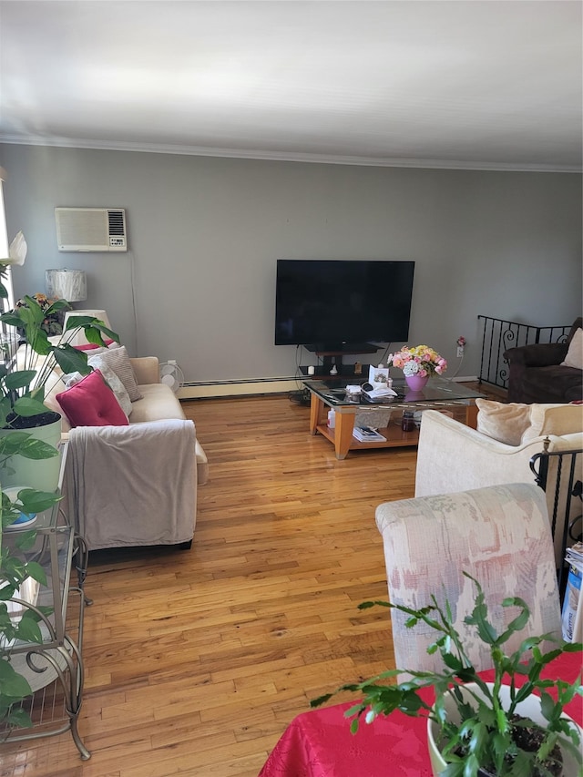 living room with ornamental molding, light wood-type flooring, a wall mounted air conditioner, and a baseboard heating unit