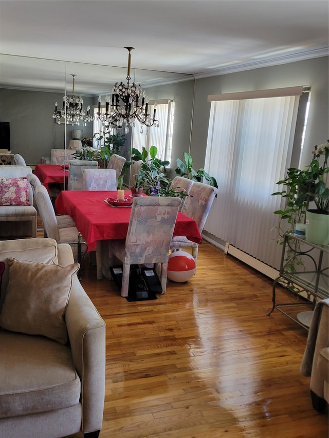 dining area featuring an inviting chandelier, ornamental molding, and wood finished floors