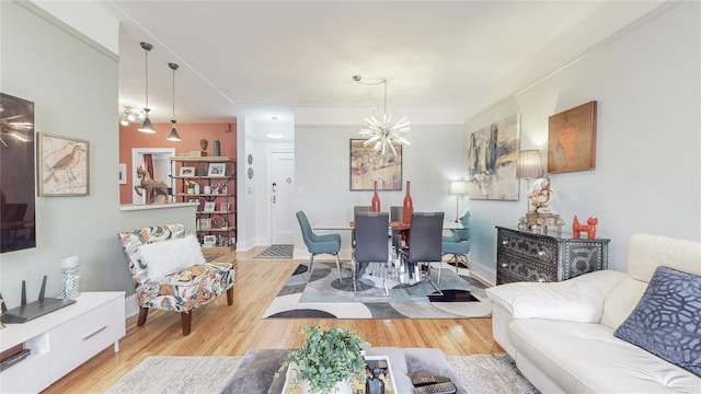 living room featuring baseboards, wood finished floors, and a notable chandelier