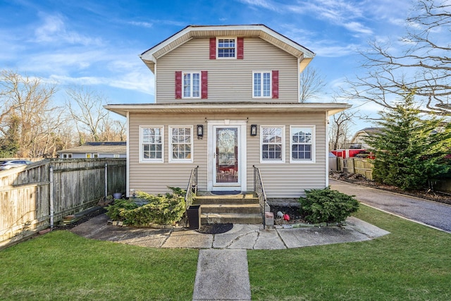 view of front facade featuring a front lawn and fence