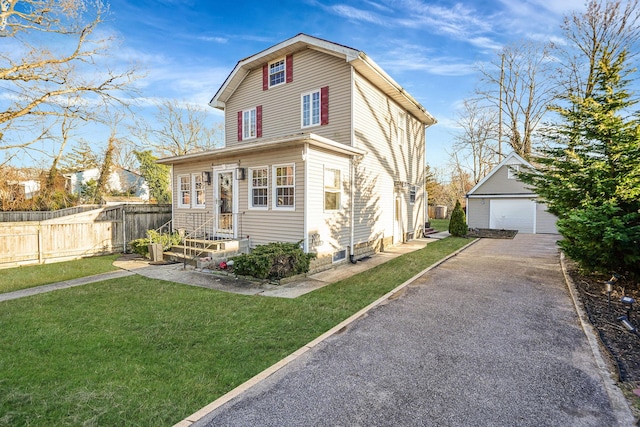 view of front of house with an outdoor structure, a garage, fence, and a front lawn