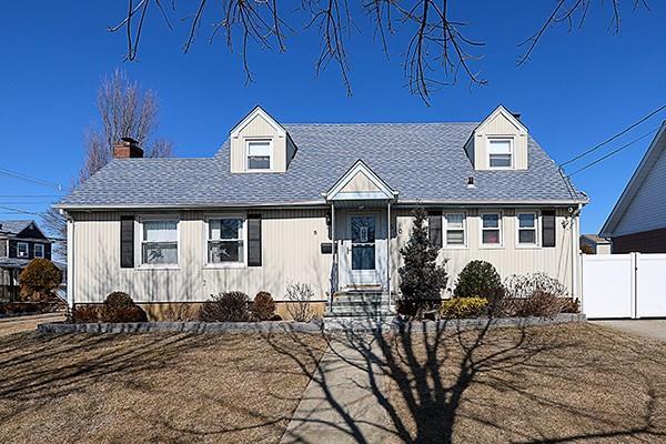 cape cod house featuring a shingled roof and fence