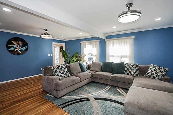 living room featuring baseboards, ornamental molding, wood finished floors, beam ceiling, and recessed lighting